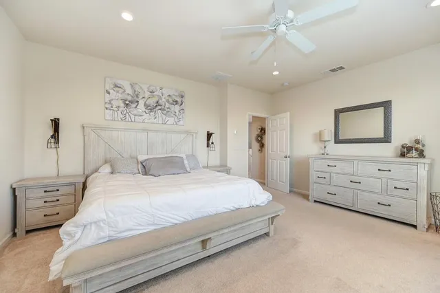 a bedroom with a bed a chandelier and a painting on the wall