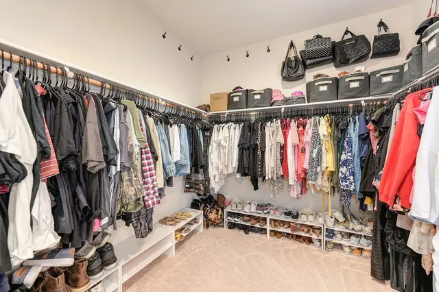 a view of walk in closet with clothes and shoes