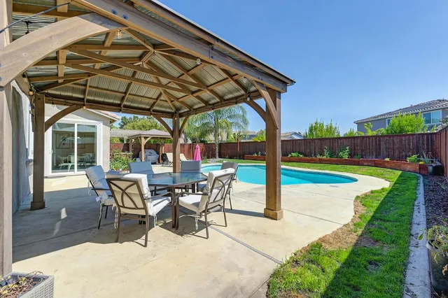 a view of a patio with a table and chairs under an umbrella