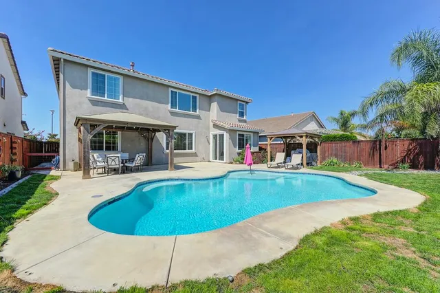 a view of a house with swimming pool and sitting area