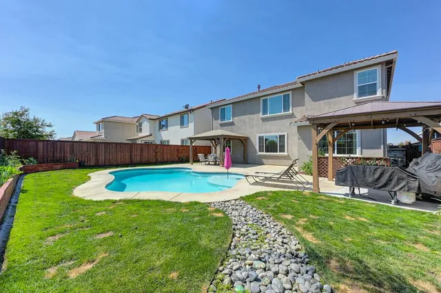 a view of a house with a yard and sitting area