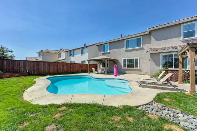 a view of a house with backyard and swimming pool