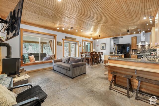 2029 West Tollgate Road Coalville, UT 84017 - Photo 6 of 43 Living area with a wood stove, concrete flooring, wood ceiling, crown molding, and french doors