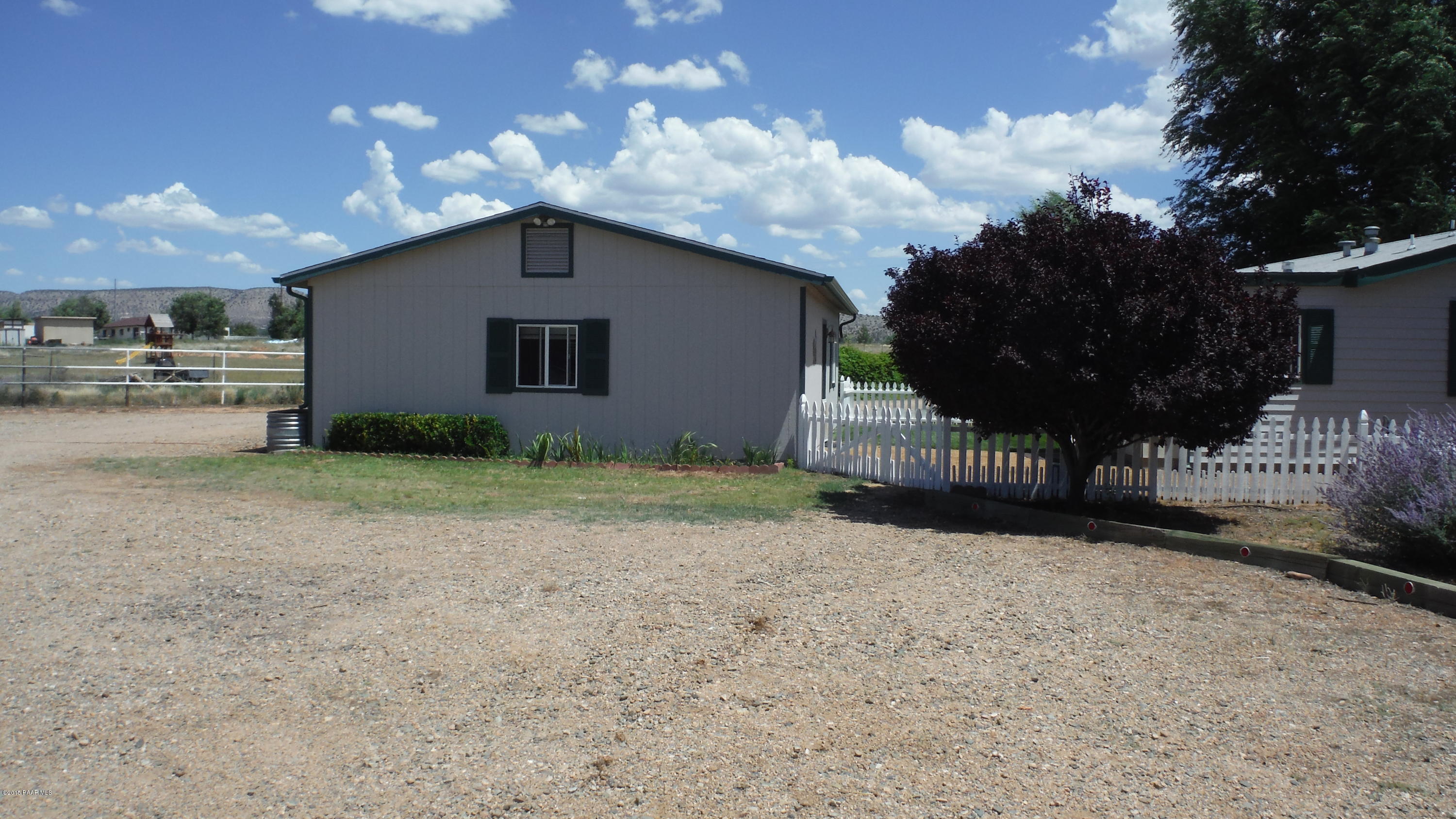 25356 North High Desert Road Paulden, AZ 86334 - Photo 20 of 56 a view of a house with a small yard and a large tree