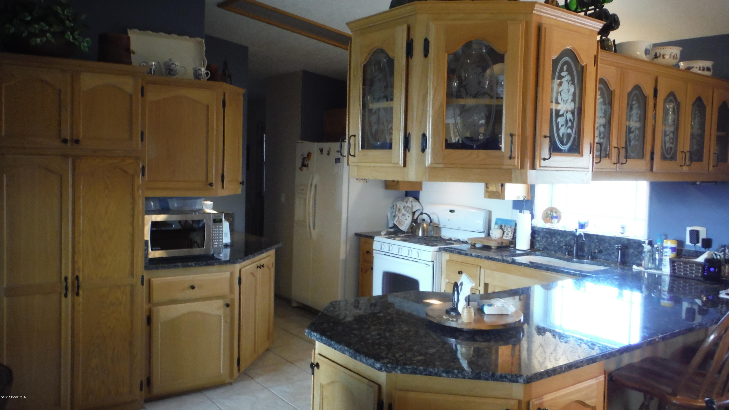 25356 North High Desert Road Paulden, AZ 86334 - Photo 41 of 56 a kitchen with granite countertop a sink a stove and cabinets