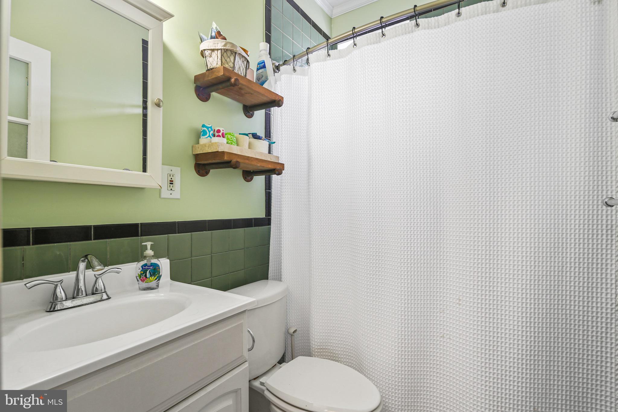 701 Grundy Street Baltimore, MD 21224 - Photo 12 of 22 a bathroom with a sink a toilet and mirror