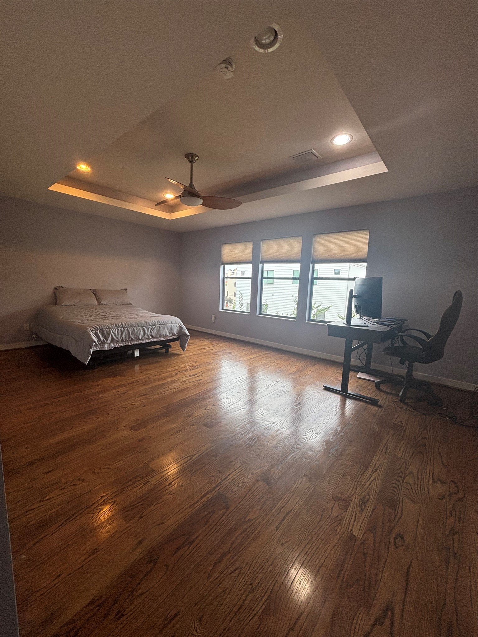 6016 Truro Street Houston, TX 77007 - Photo 15 of 26 Expansive third-floor primary suite featuring hardwood floors, a tray ceiling with ambient lightings, abundant natural light, and exceptional privacy.