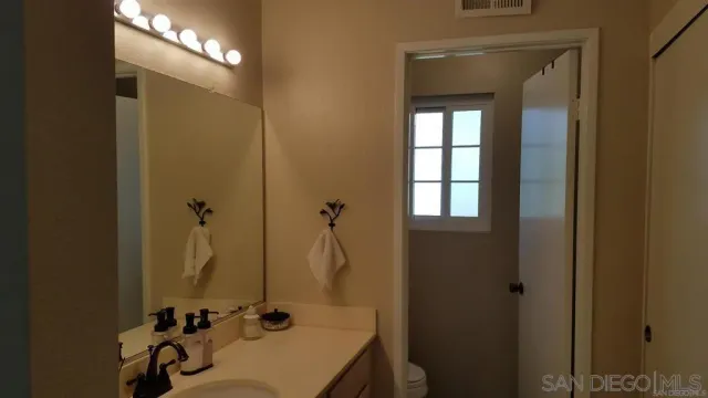 a bathroom with a sink a toilet and a mirror