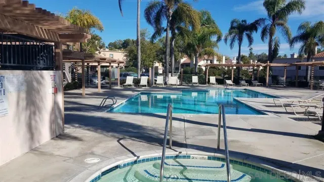 a view of a swimming pool with a patio and a yard