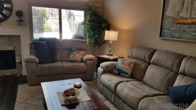 a living room with furniture a fireplace and a large window