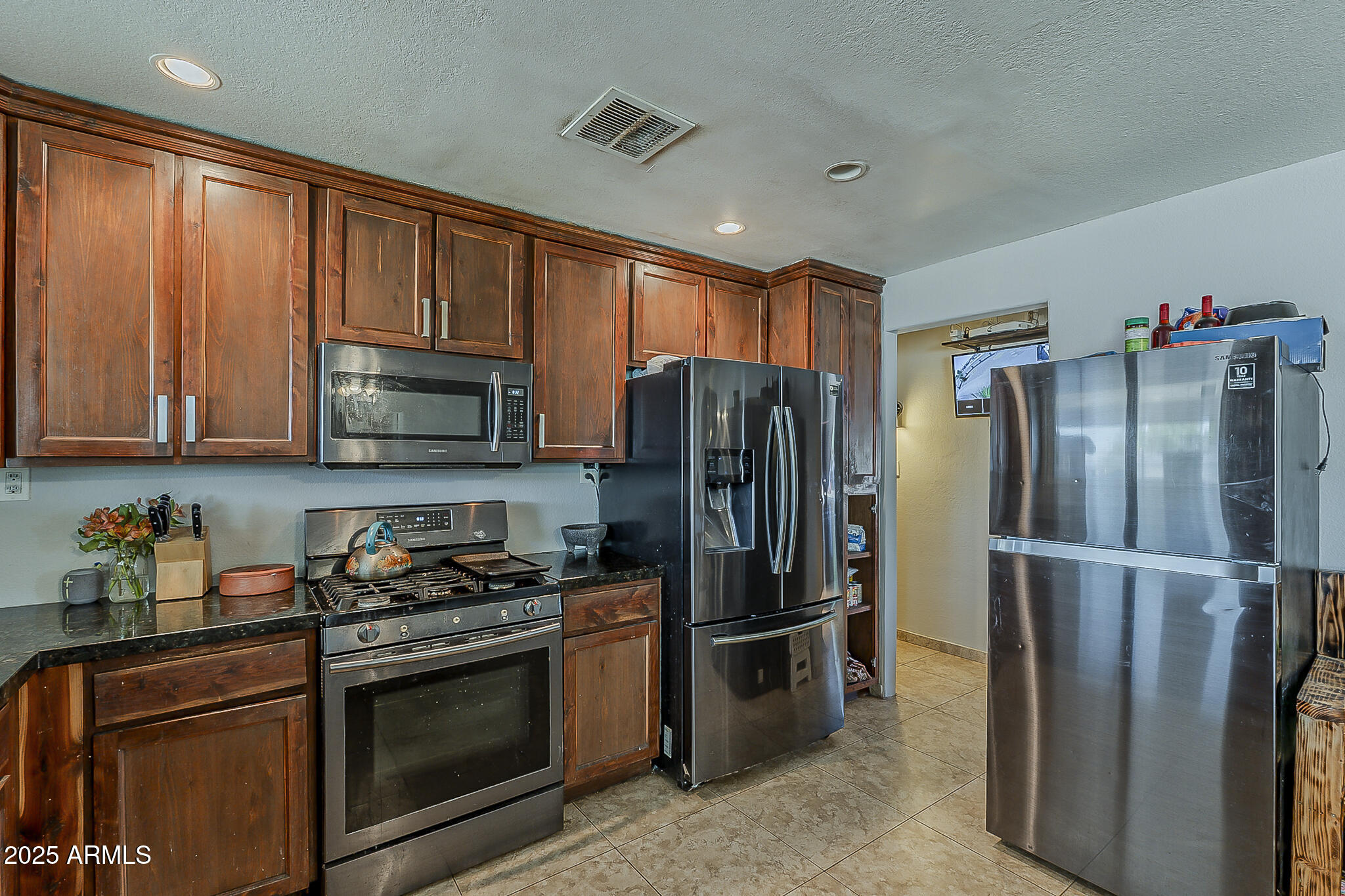5319 West Osborn Road Phoenix, AZ 85031 - Photo 15 of 37 a kitchen with stainless steel appliances granite countertop a refrigerator stove and microwave