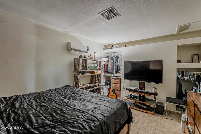 a bedroom with a bed and a flat screen tv