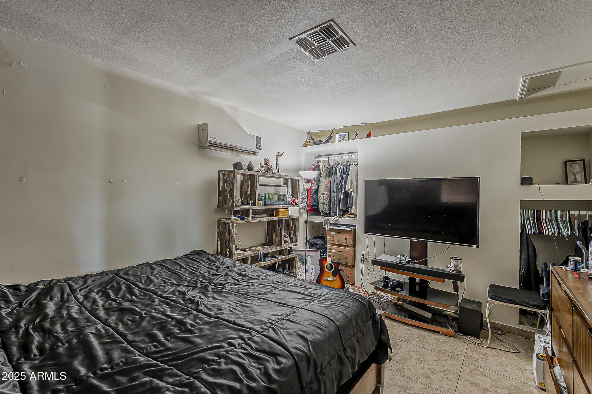 5319 West Osborn Road Phoenix, AZ 85031 - Photo 18 of 37 a bedroom with a bed and a flat screen tv