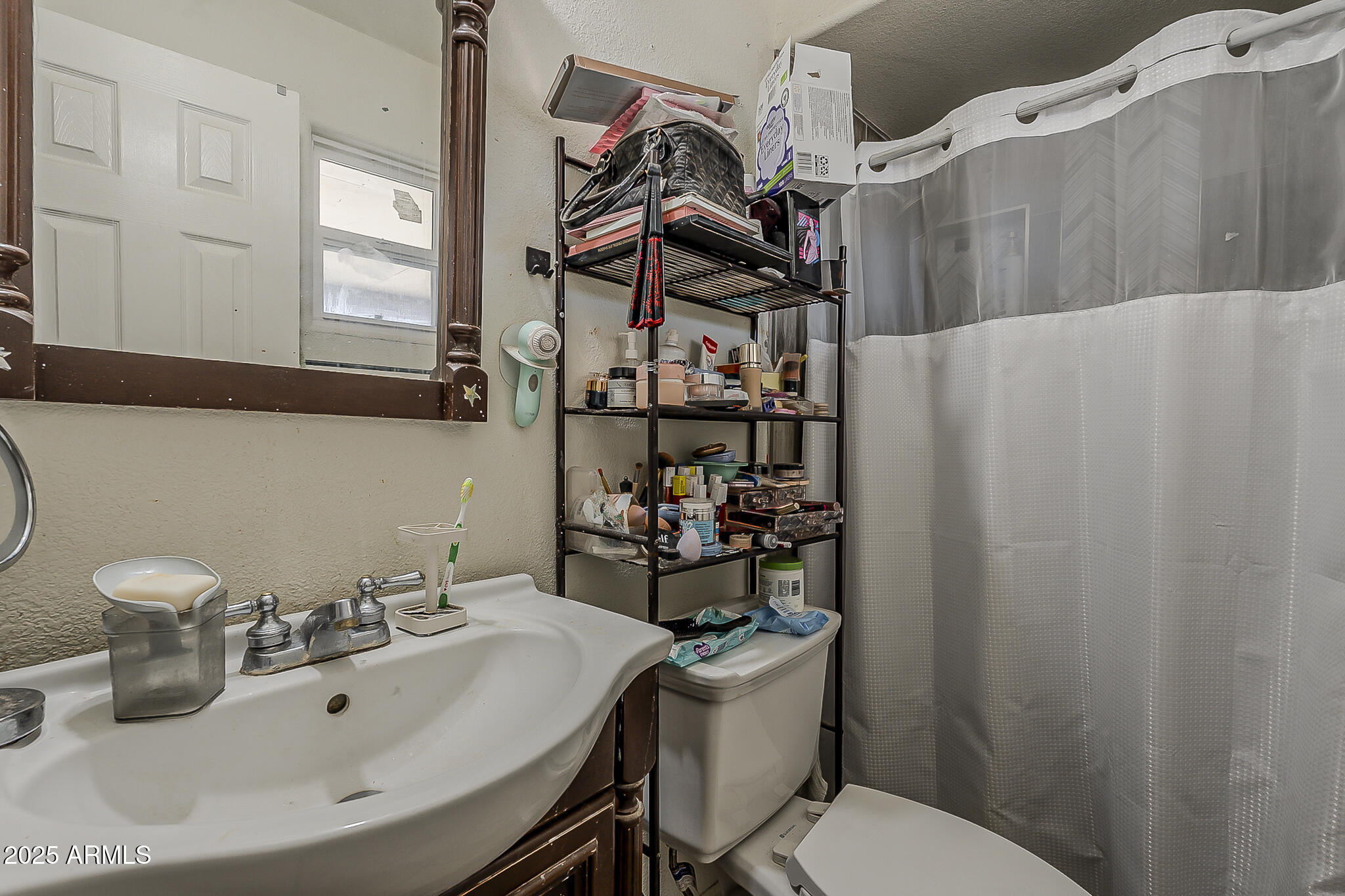 5319 West Osborn Road Phoenix, AZ 85031 - Photo 23 of 37 a bathroom with a sink mirror and toilet