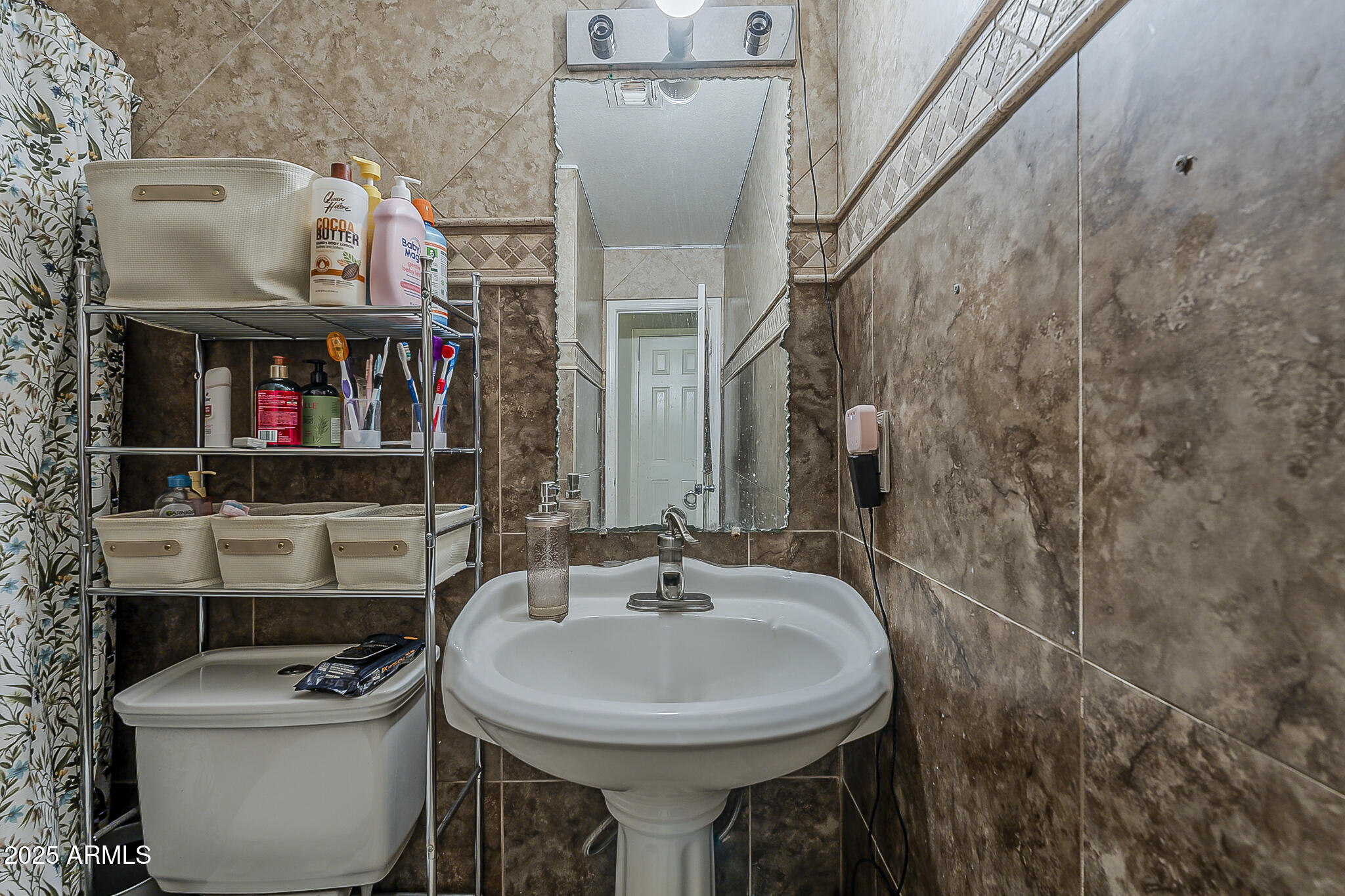 5319 West Osborn Road Phoenix, AZ 85031 - Photo 27 of 37 a bathroom with a toilet sink and mirror