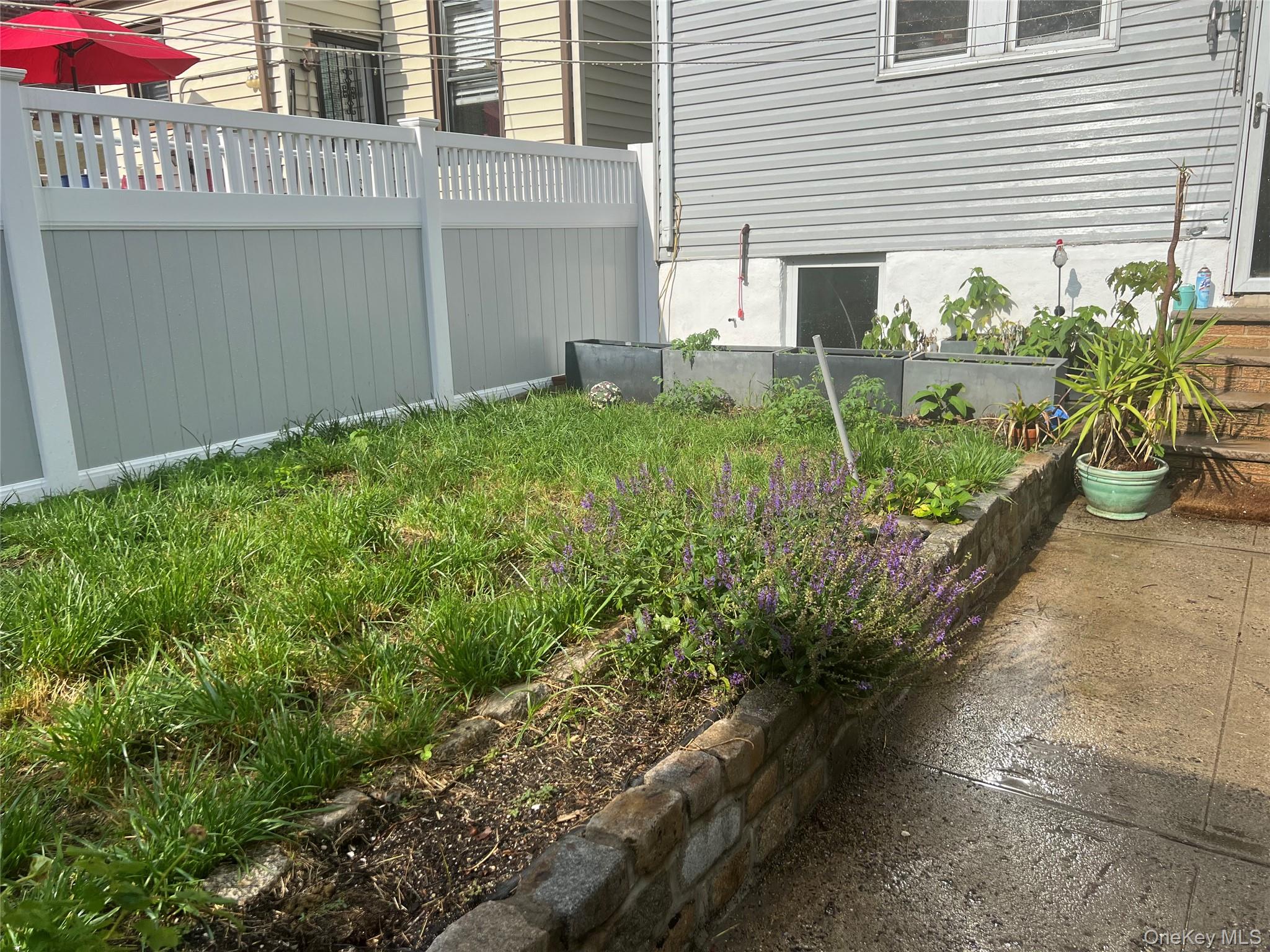 22-26 74th Street Queens, NY 11370 - Photo 15 of 19 a front view of a house with garden