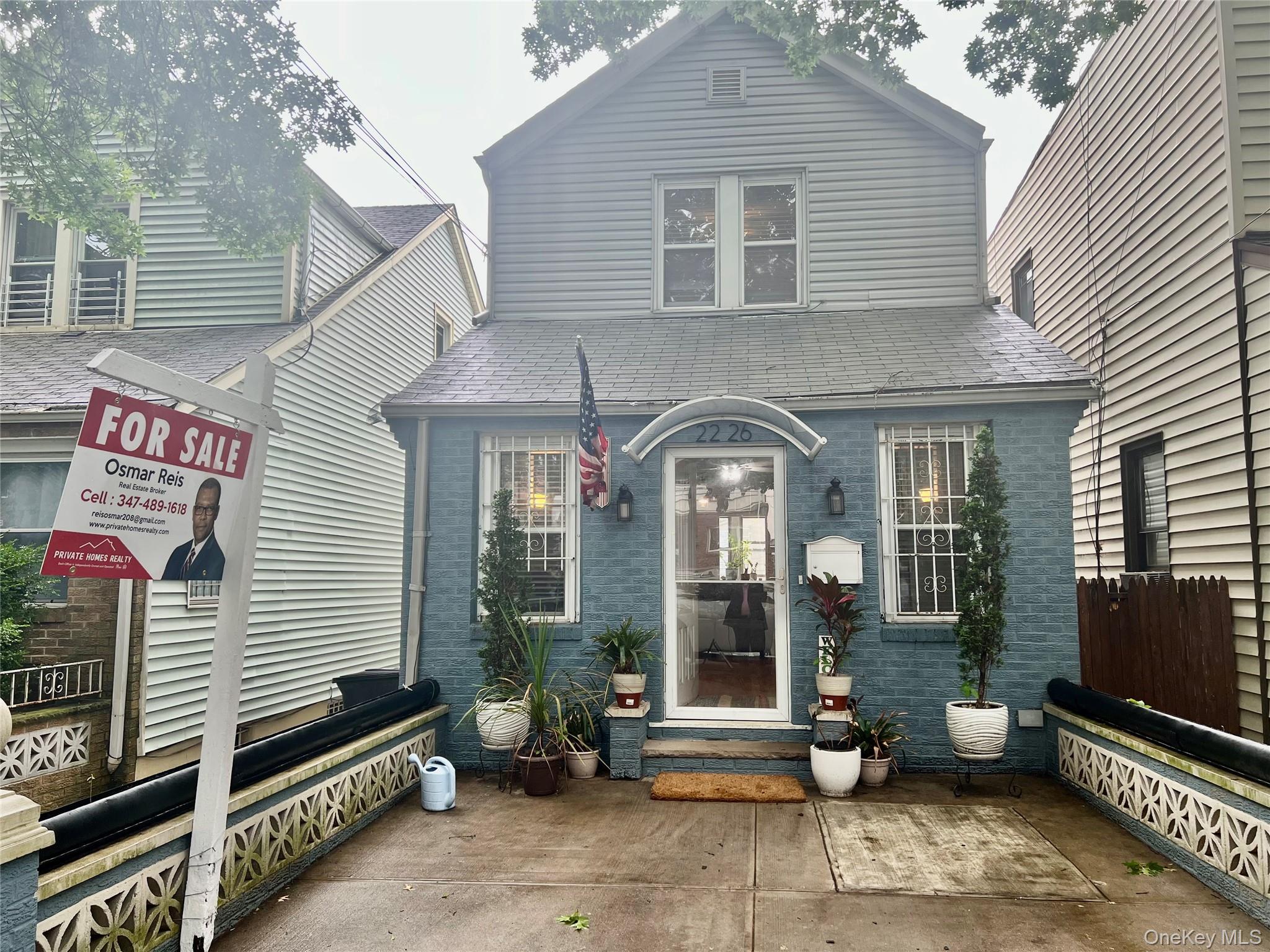 22-26 74th Street Queens, NY 11370 - Photo 18 of 19 a front view of a house with a garden