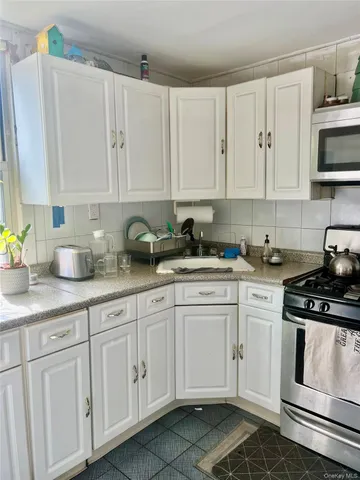 a kitchen with white cabinets and white appliances