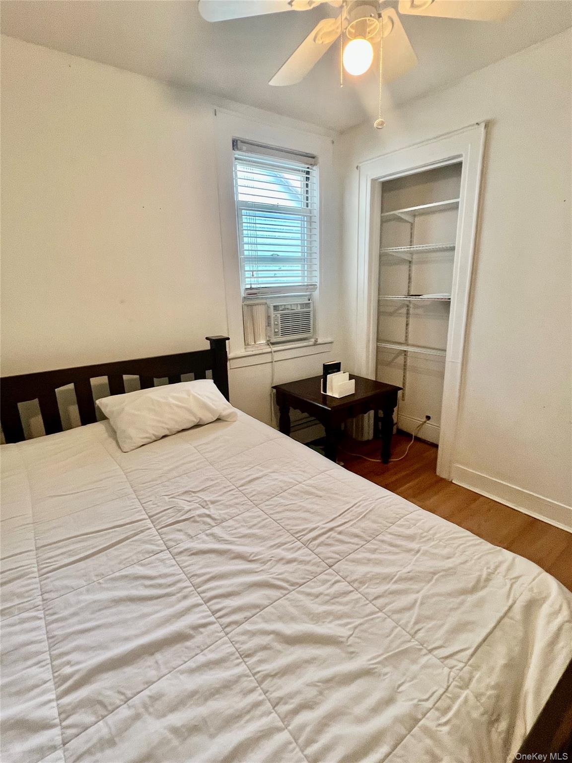 22-26 74th Street Queens, NY 11370 - Photo 10 of 19 a bedroom with a bed and wooden floor