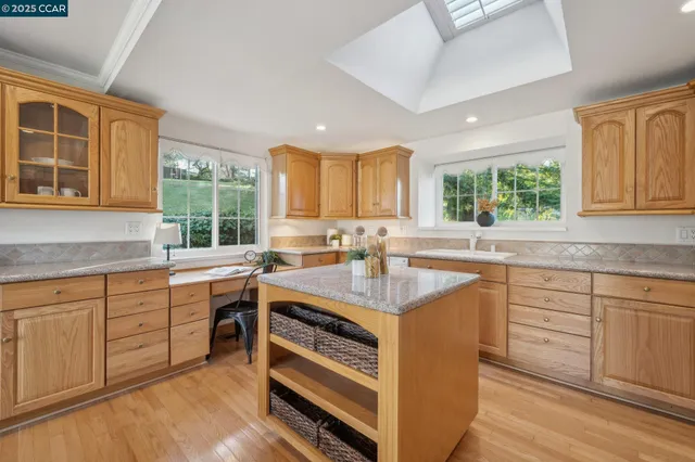 a kitchen with granite countertop a stove a sink and cabinets