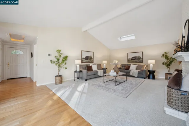 a living room with furniture a fireplace and a large window