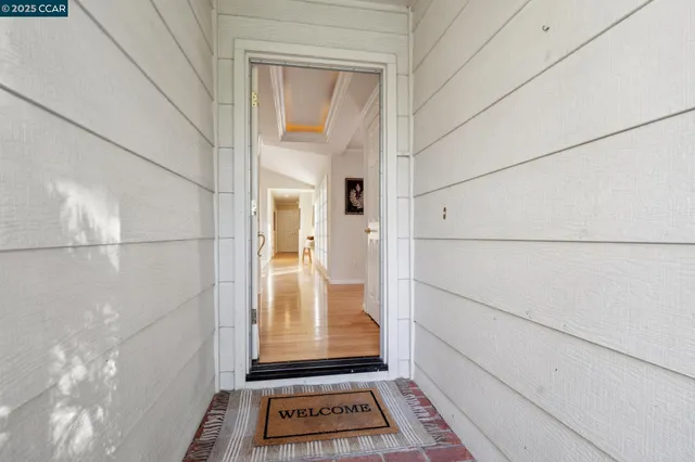 a view of a hallway with wooden floor and windows