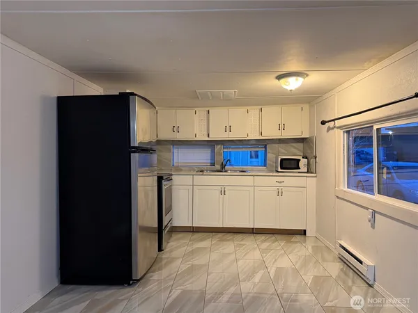 a kitchen with stainless steel appliances granite countertop a refrigerator and a stove top oven