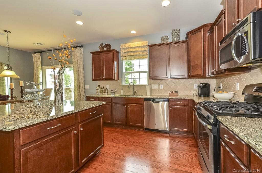 79184 Ridgehaven Road, Unit 295 Lancaster, SC 29720 - Photo 5 of 19 a kitchen with stainless steel appliances granite countertop wooden cabinets stove top oven and sink