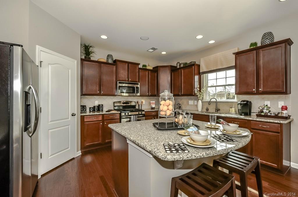 79184 Ridgehaven Road, Unit 295 Lancaster, SC 29720 - Photo 8 of 19 a kitchen with refrigerator cabinets dining table and chairs