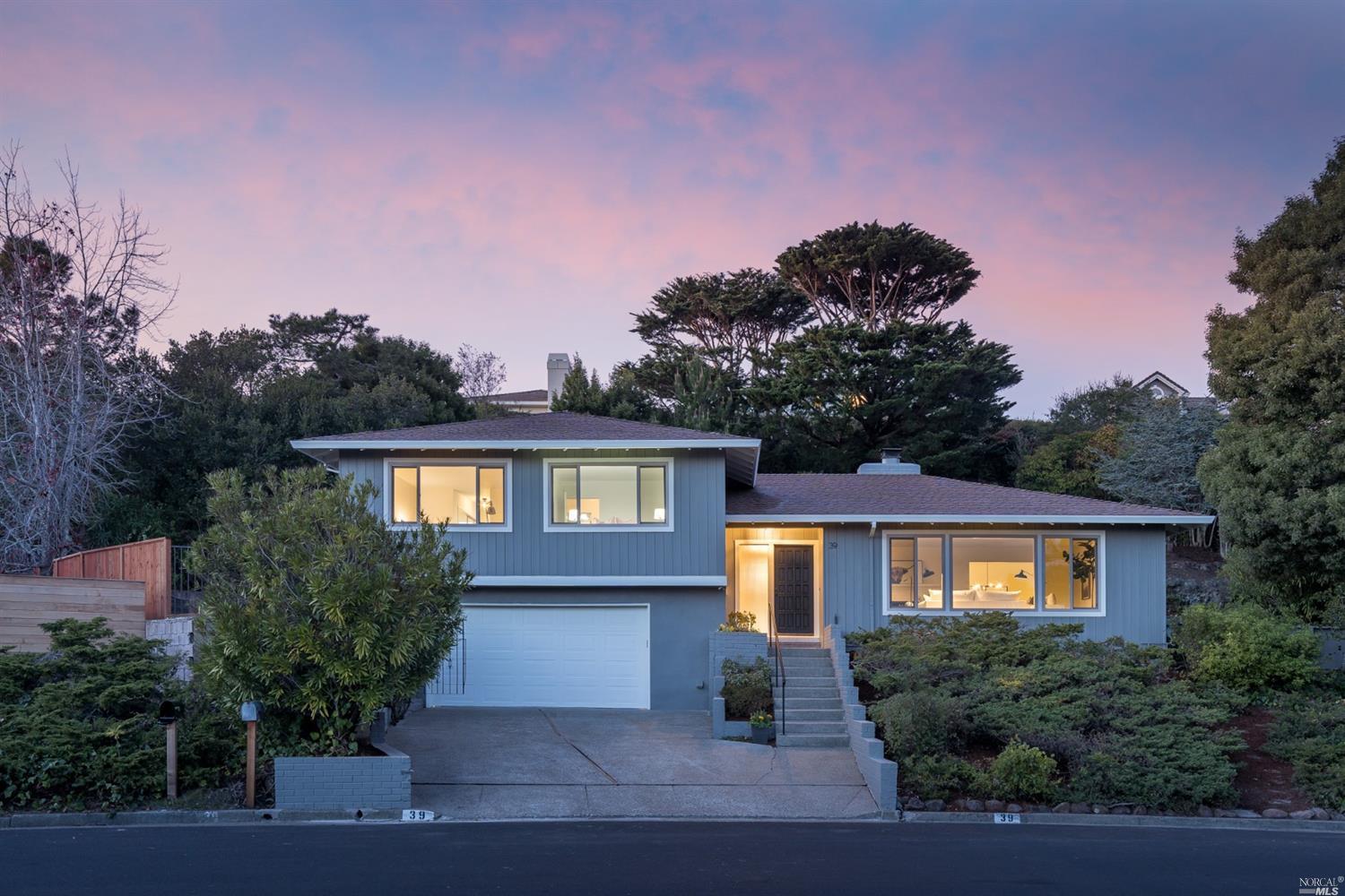 a front view of a house with yard and trees