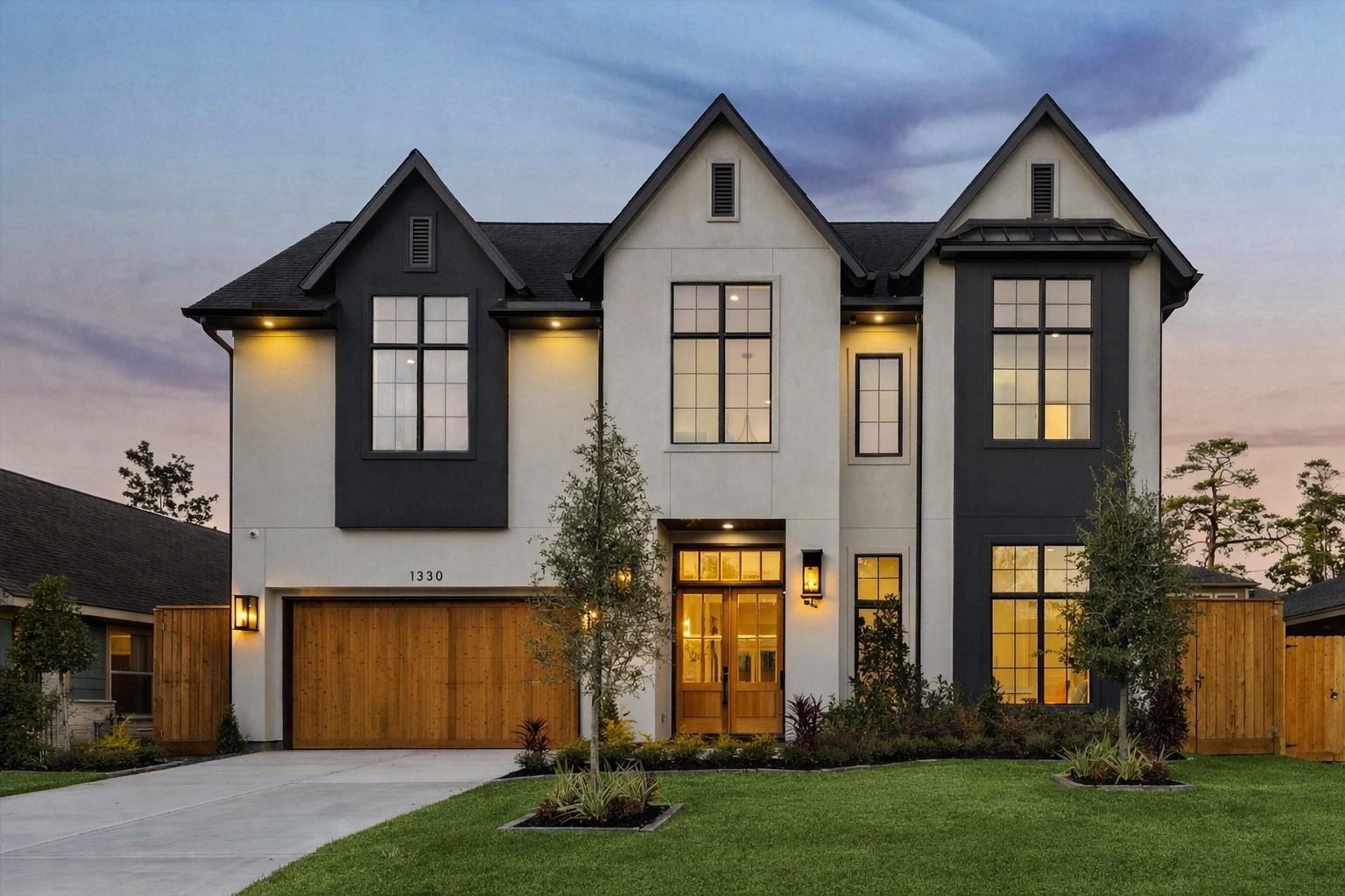 A thoughtfully designed elevation blends modern lines with classic proportions, creating strong curb appeal while fitting seamlessly into the surrounding neighborhood. Dual drive access, a spacious garage, and a welcoming front entry enhance everyday functionality, while architectural lighting and mature landscaping elevate the home’s presence from day to night.