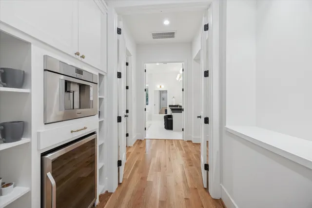 a view of a hallway with wooden floor and staircase