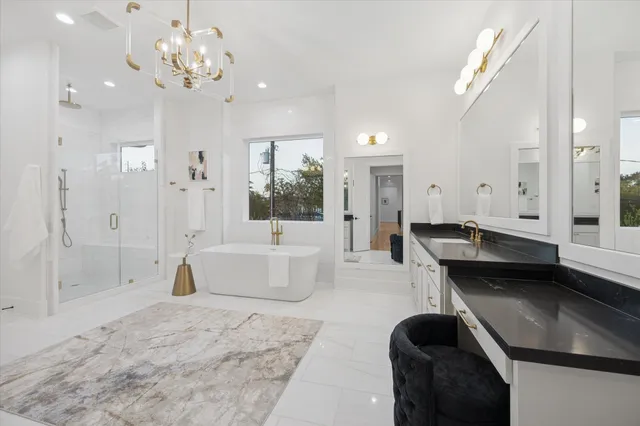 a large white kitchen with a large window and stainless steel appliances