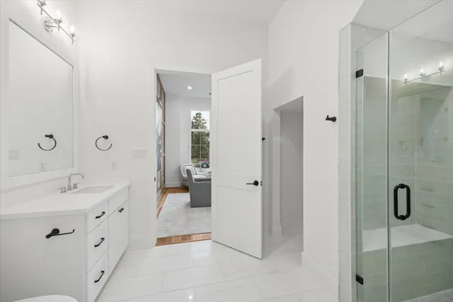 a spacious bathroom with a shower sink and mirror