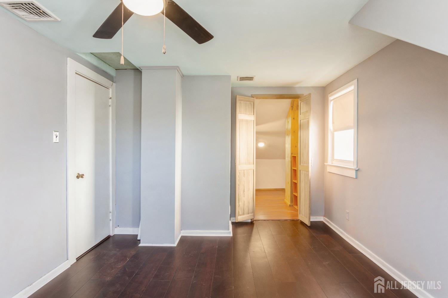 83 South Maple Avenue Springfield, NJ 07081 - Photo 16 of 38 a view of an empty room with wooden floor and a window
