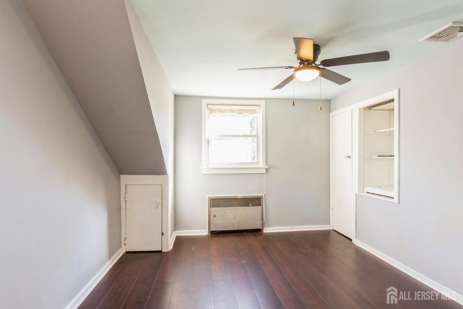 83 South Maple Avenue Springfield, NJ 07081 - Photo 17 of 38 an empty room with wooden floor ceiling fan and windows