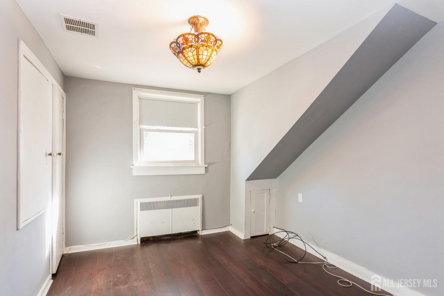 83 South Maple Avenue Springfield, NJ 07081 - Photo 20 of 38 a view of an empty room with wooden floor and a window