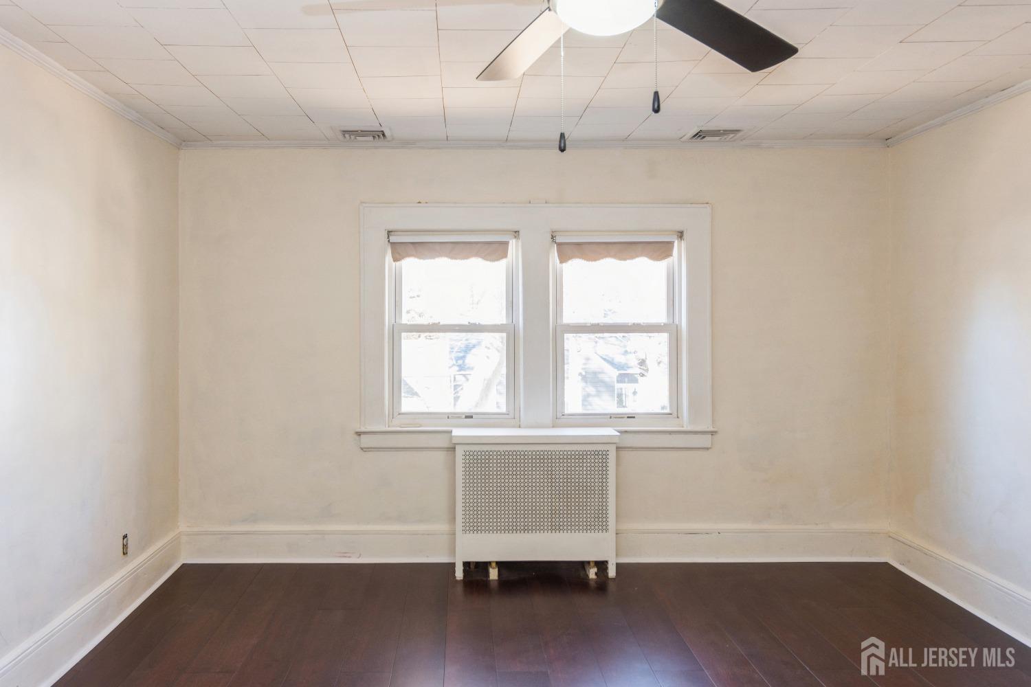 83 South Maple Avenue Springfield, NJ 07081 - Photo 23 of 38 an empty room with wooden floor ceiling fan and windows