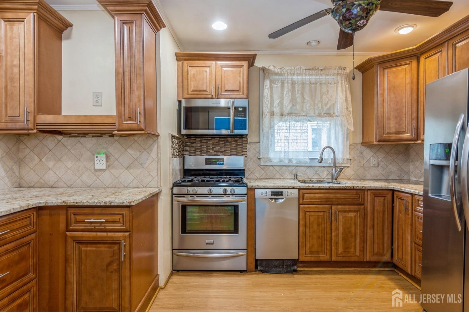 83 South Maple Avenue Springfield, NJ 07081 - Photo 5 of 38 a kitchen with stainless steel appliances granite countertop a stove a sink and a microwave