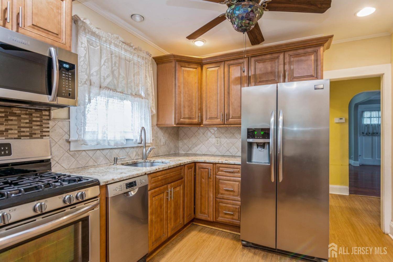 83 South Maple Avenue Springfield, NJ 07081 - Photo 6 of 38 a kitchen with stainless steel appliances granite countertop a refrigerator and a stove top oven