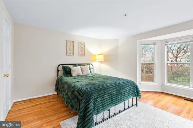 a bedroom with a bed and wooden floor