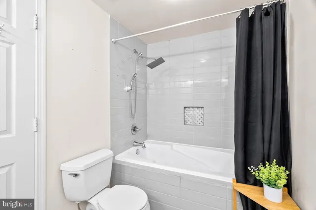 a bathroom with a toilet and a shower curtain