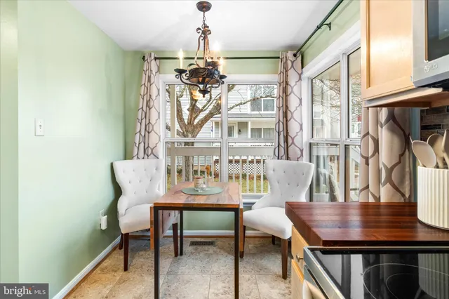 a view of a dining room with furniture a chandelier and wooden floor