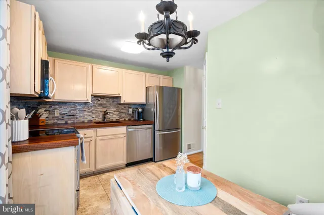 a kitchen with stainless steel appliances granite countertop a sink and a refrigerator