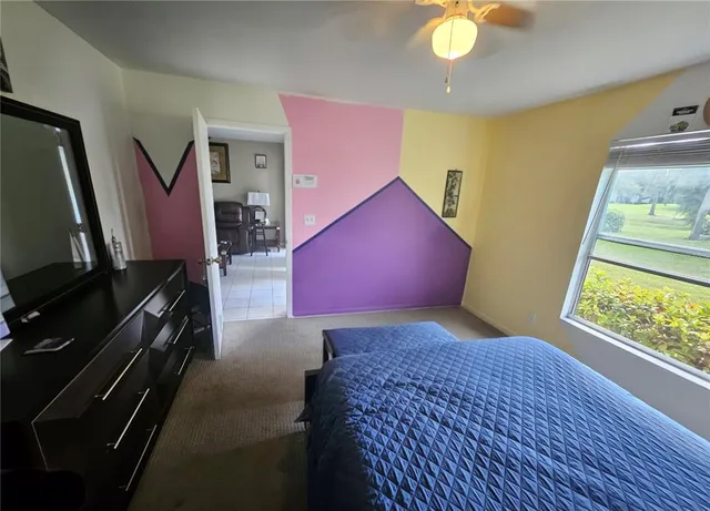 a bedroom with a bed and a flat tv screen on dresser