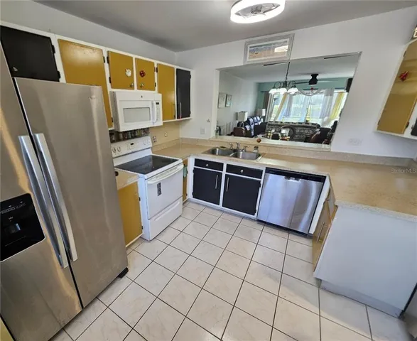 a kitchen with stainless steel appliances a refrigerator sink and stove