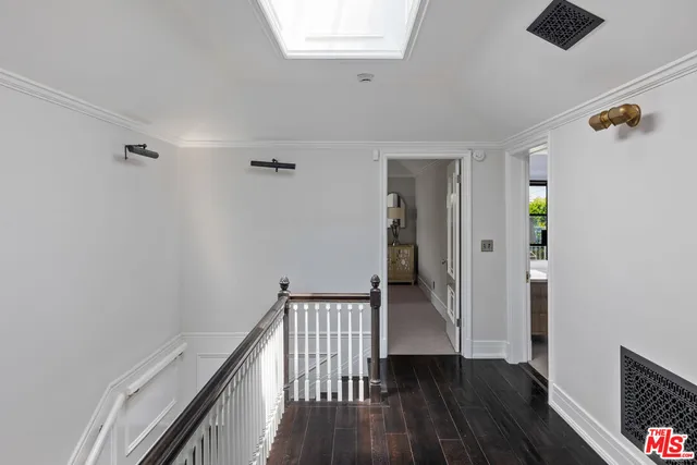 a view of a hallway with wooden floor and stairs