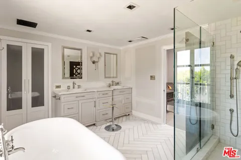 a spacious bathroom with a shower sink and mirror