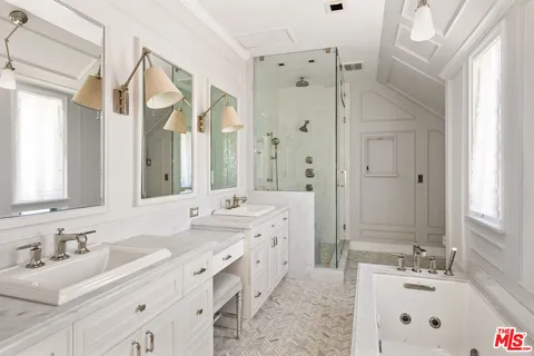 a bathroom with double vanity sinks double vanity tub shower and a mirror