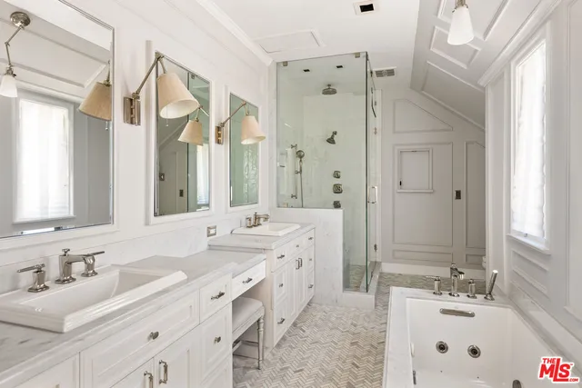 a bathroom with double vanity sinks double vanity tub shower and a mirror